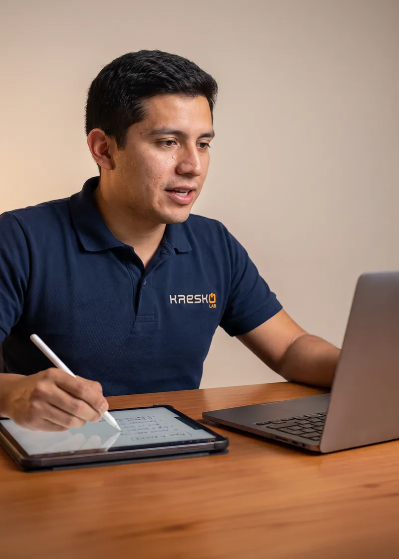 Persona impartiendo una clase en línea con una tableta y una laptop
